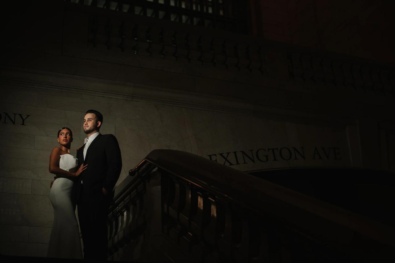 Dramatic engagement portrait on a dimly lit Grand Central staircase