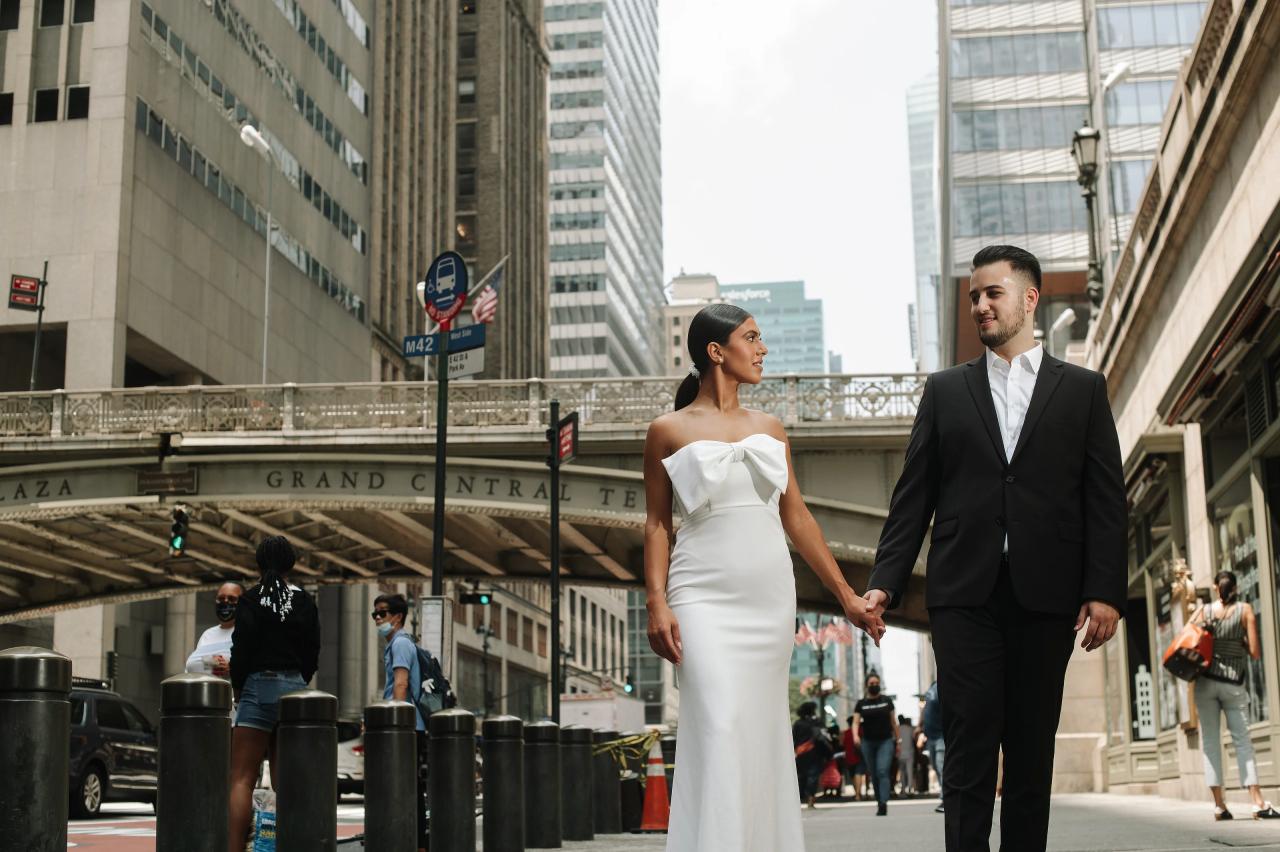 Couple walking hand in hand along a New York City sidewalk