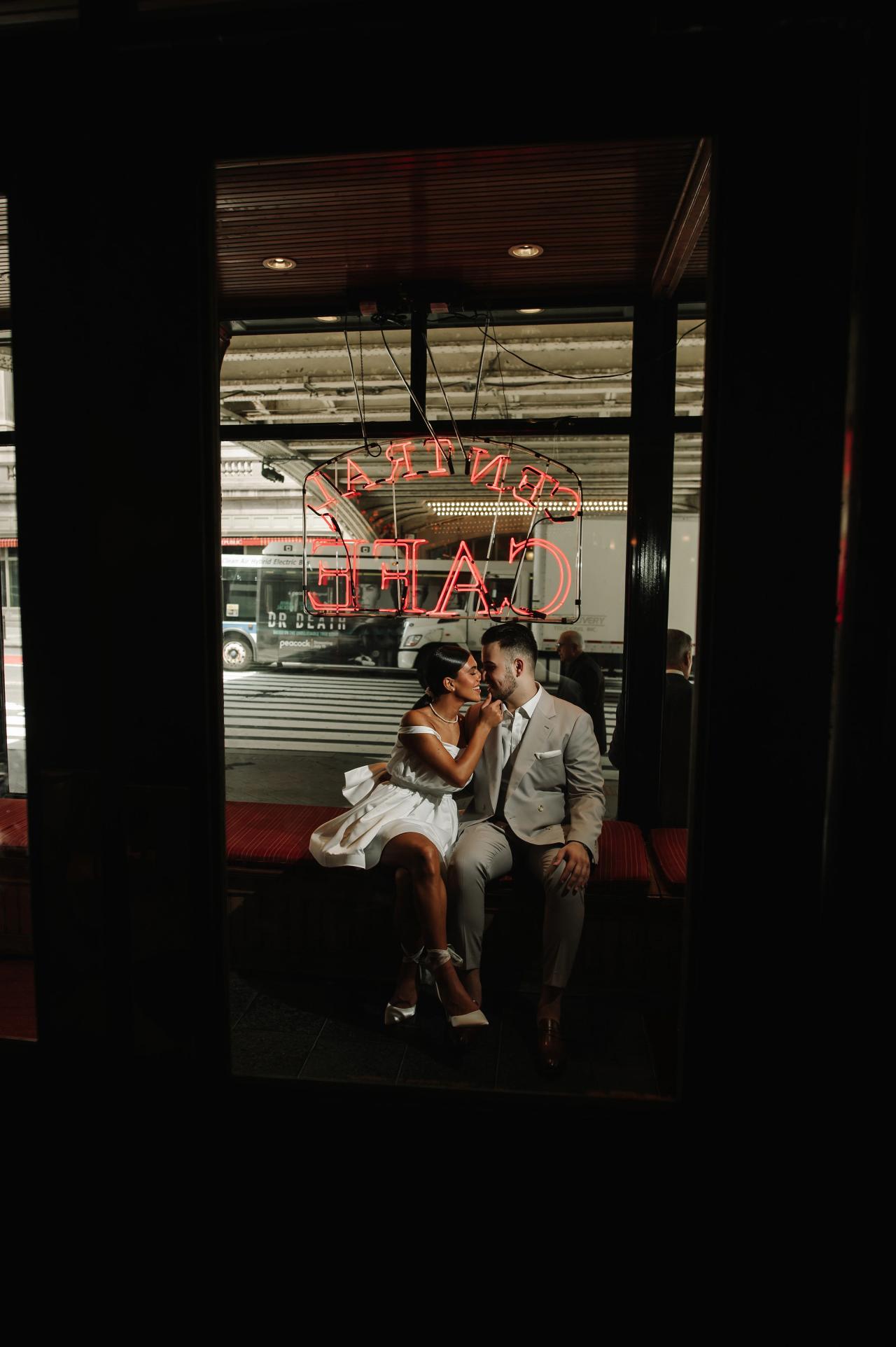 Engagement portrait framed by the doorway of a New York City cafe