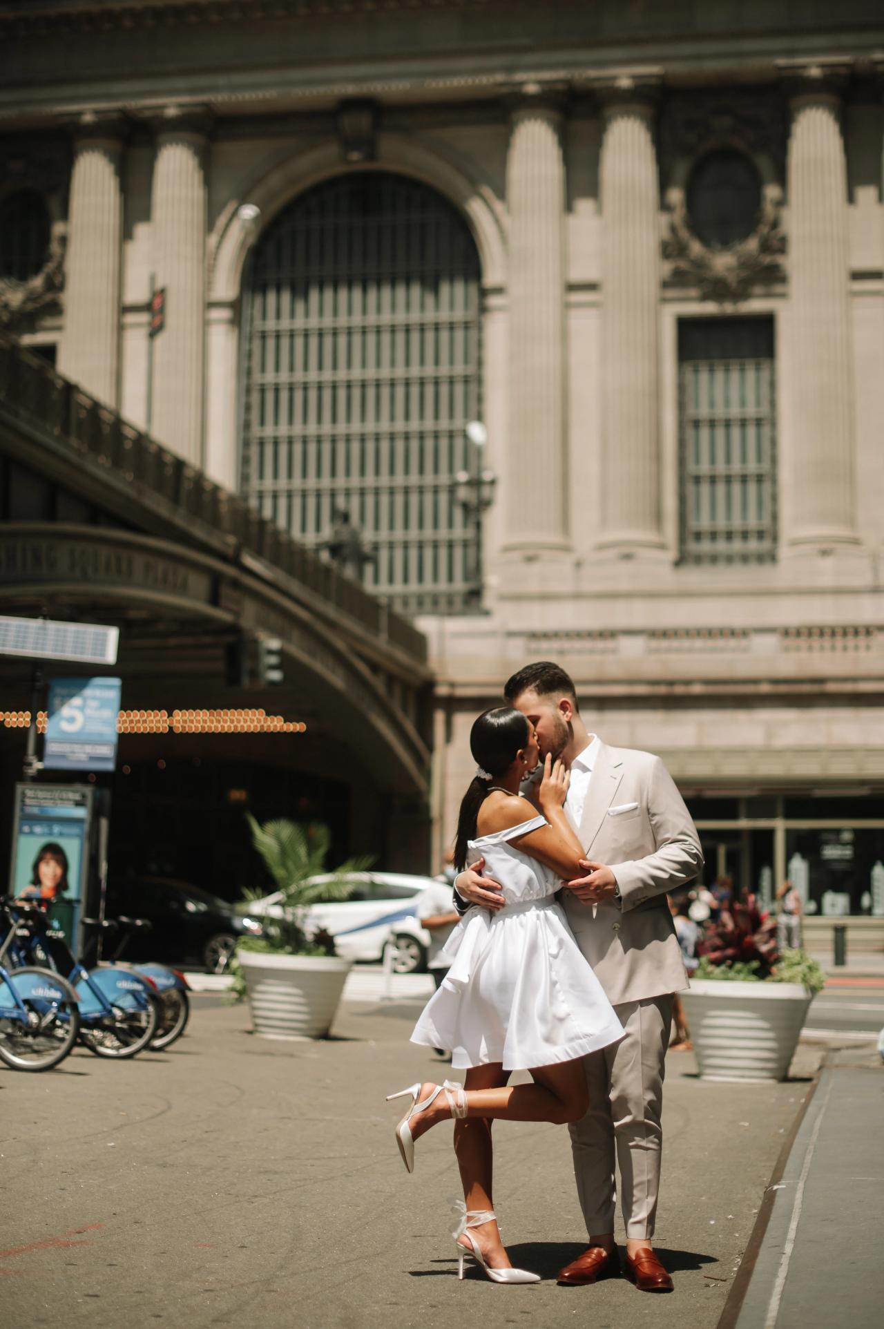 Man kissing his partner on the forehead outside Grand Central Terminal