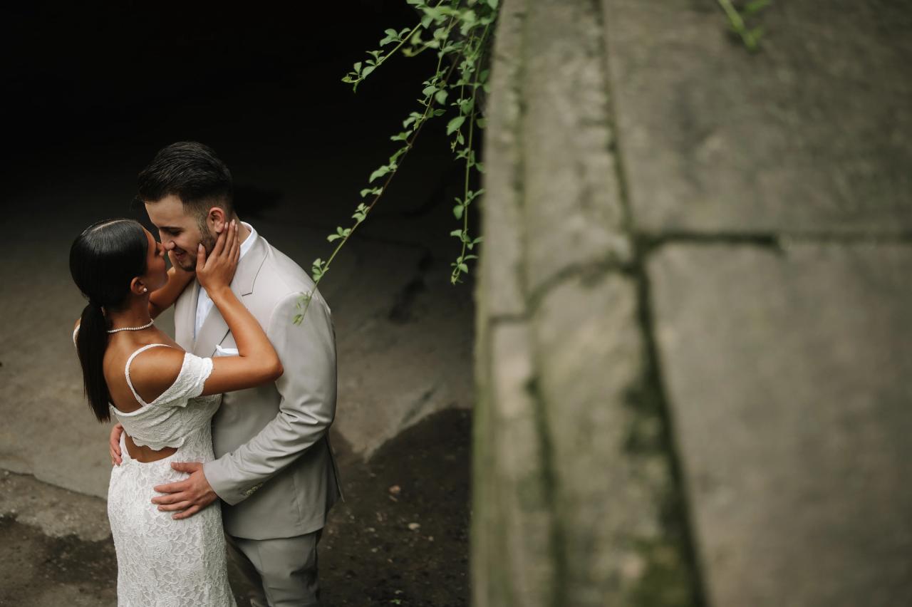 Couple kissing beside a stone wall during Central Park engagement portraits
