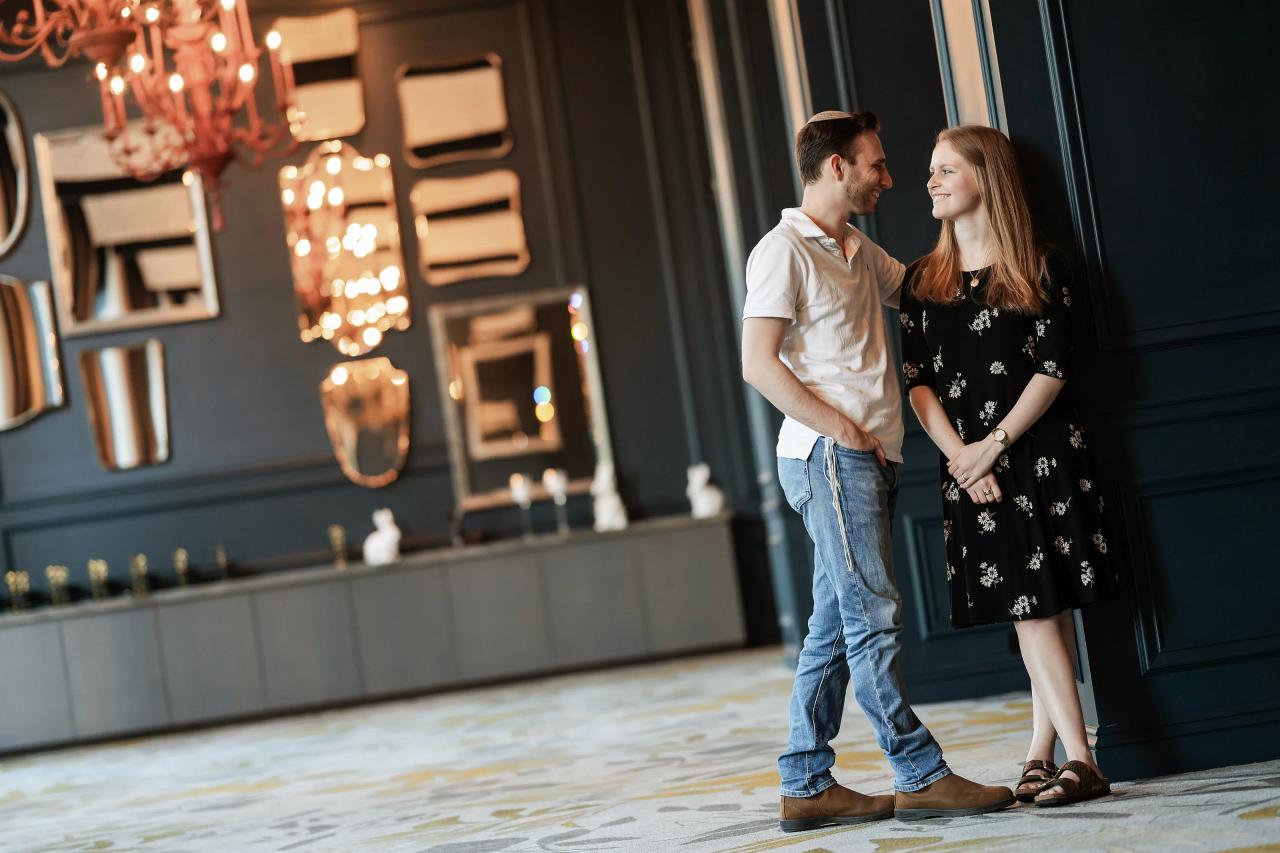 Couple standing together beneath a chandelier
