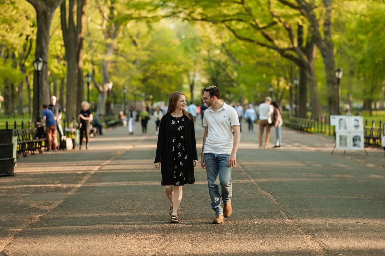 Couple walking together along a broad tree-lined path
