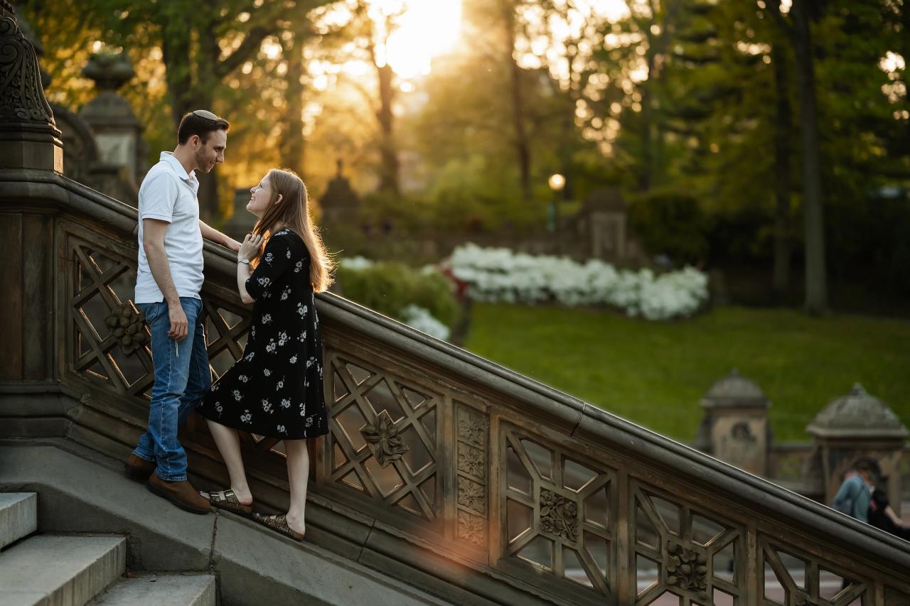 Couple holding hands on a stone stairway in warm evening light