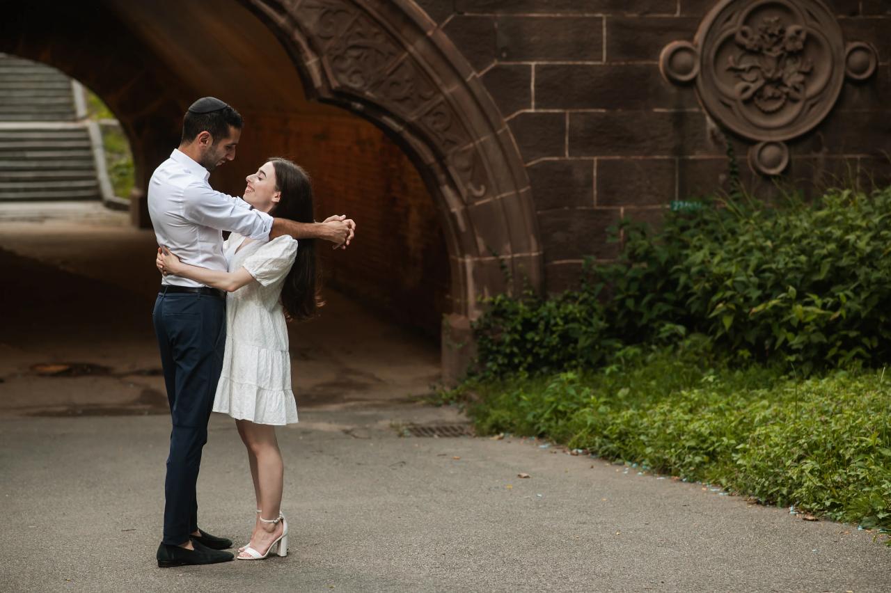 Couple embracing near a Central Park archway
