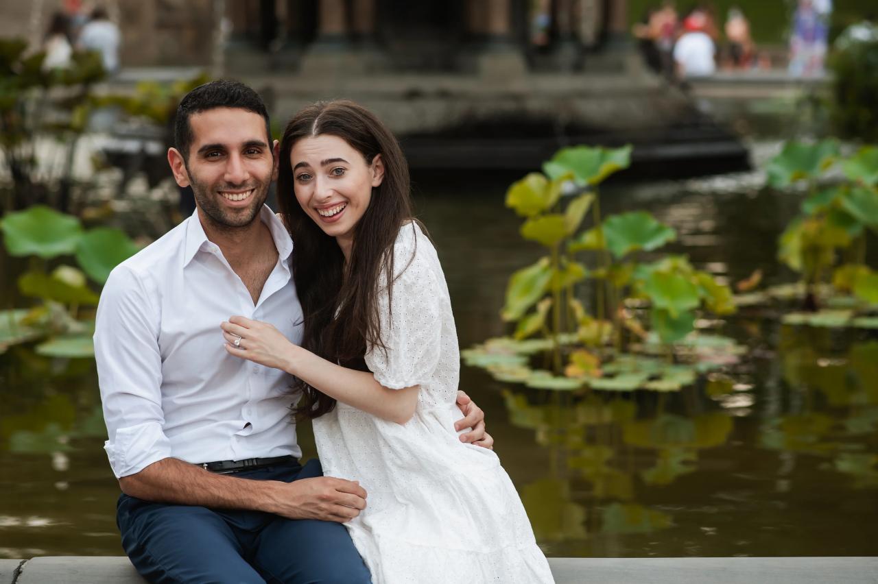 Close portrait of a smiling couple beside fountain flowers