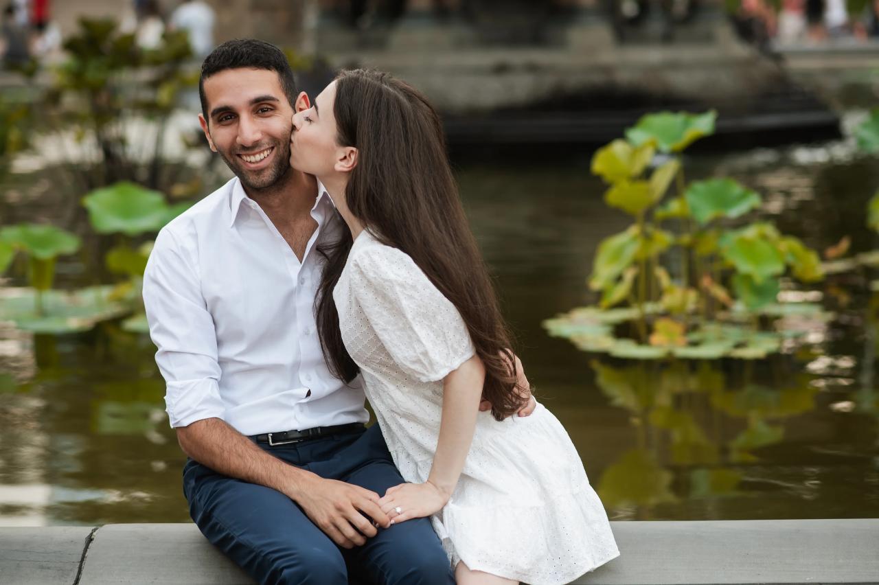 A kiss on the cheek during an engagement portrait