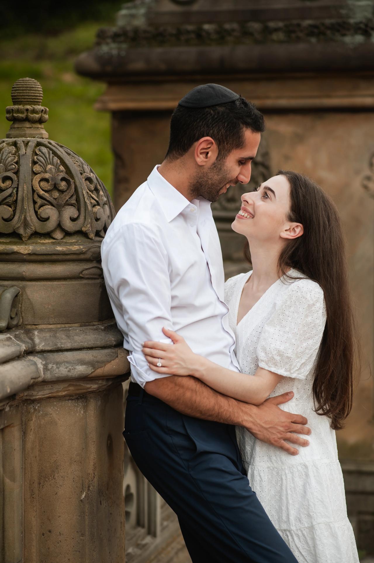 Couple kissing beside a stone terrace