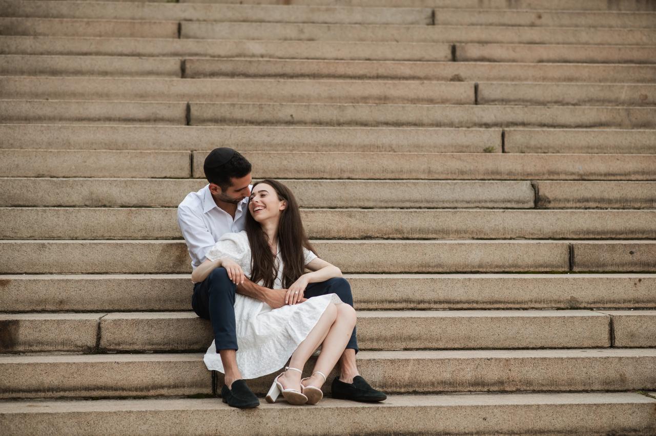 Couple kissing while seated on park steps