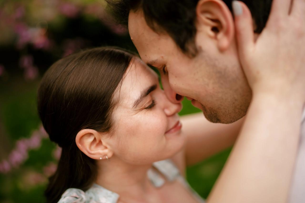 Couple touching foreheads during a garden engagement session