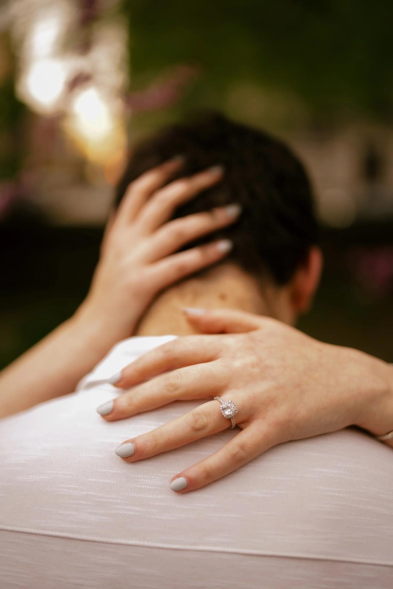 Detail of an embrace and engagement ring