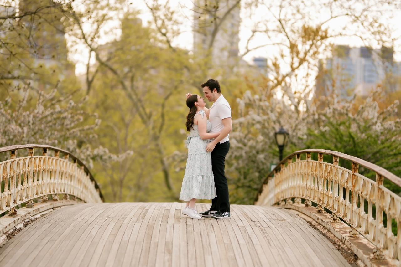 Couple embracing on a curved park footbridge