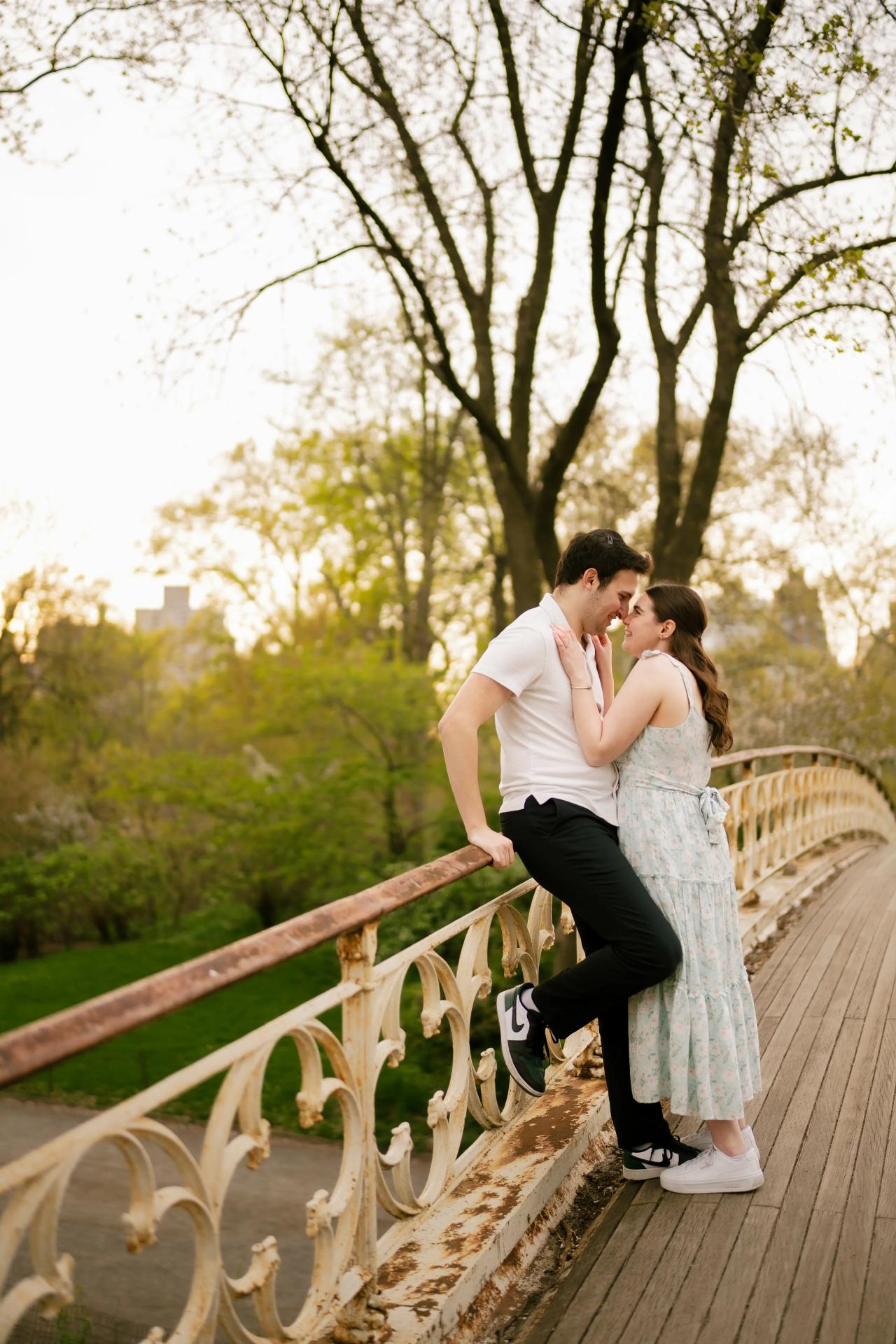 Couple kissing beside a bridge railing