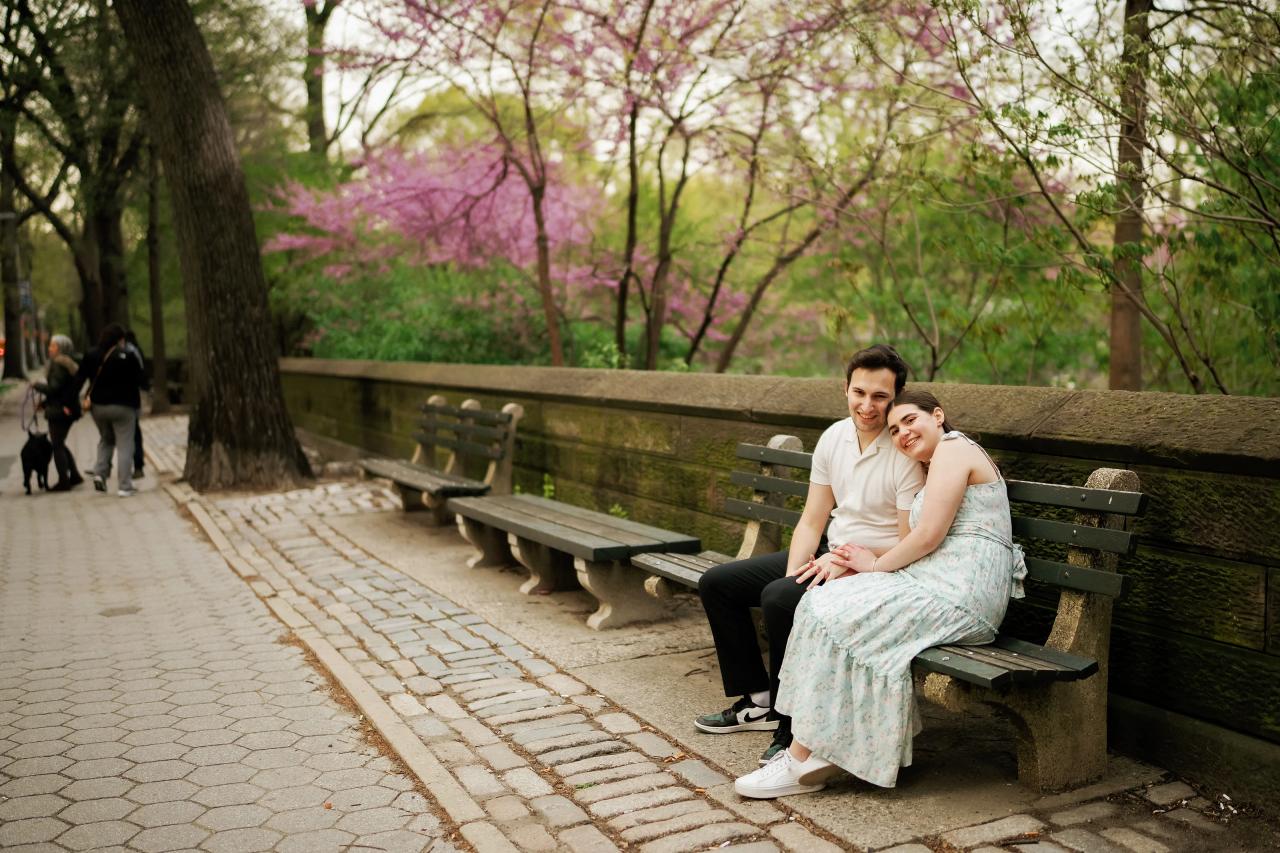 Couple smiling on a bench beside a spring park path