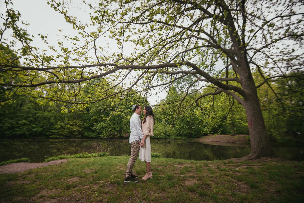 Wide portrait of a couple beneath a spreading tree