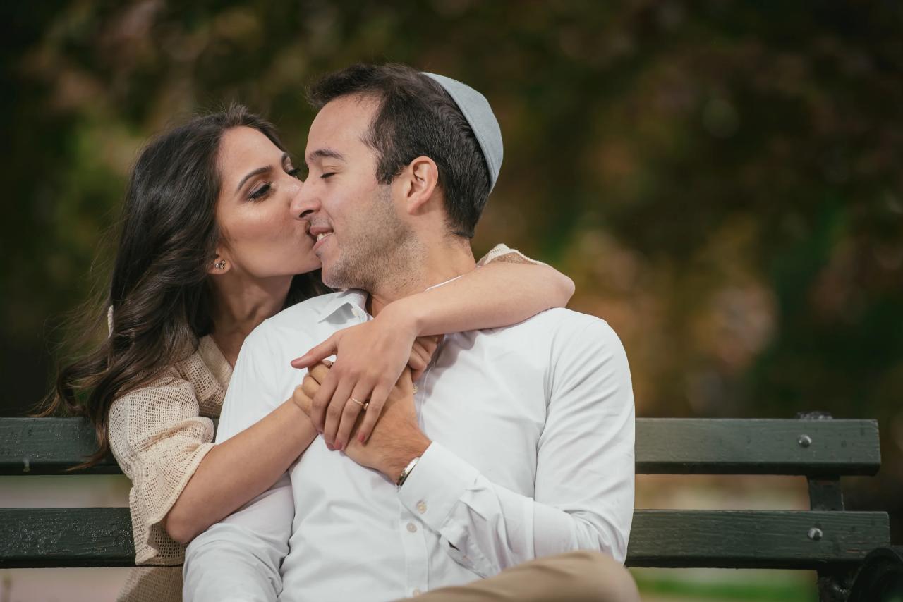 Couple sharing a kiss on a park bench