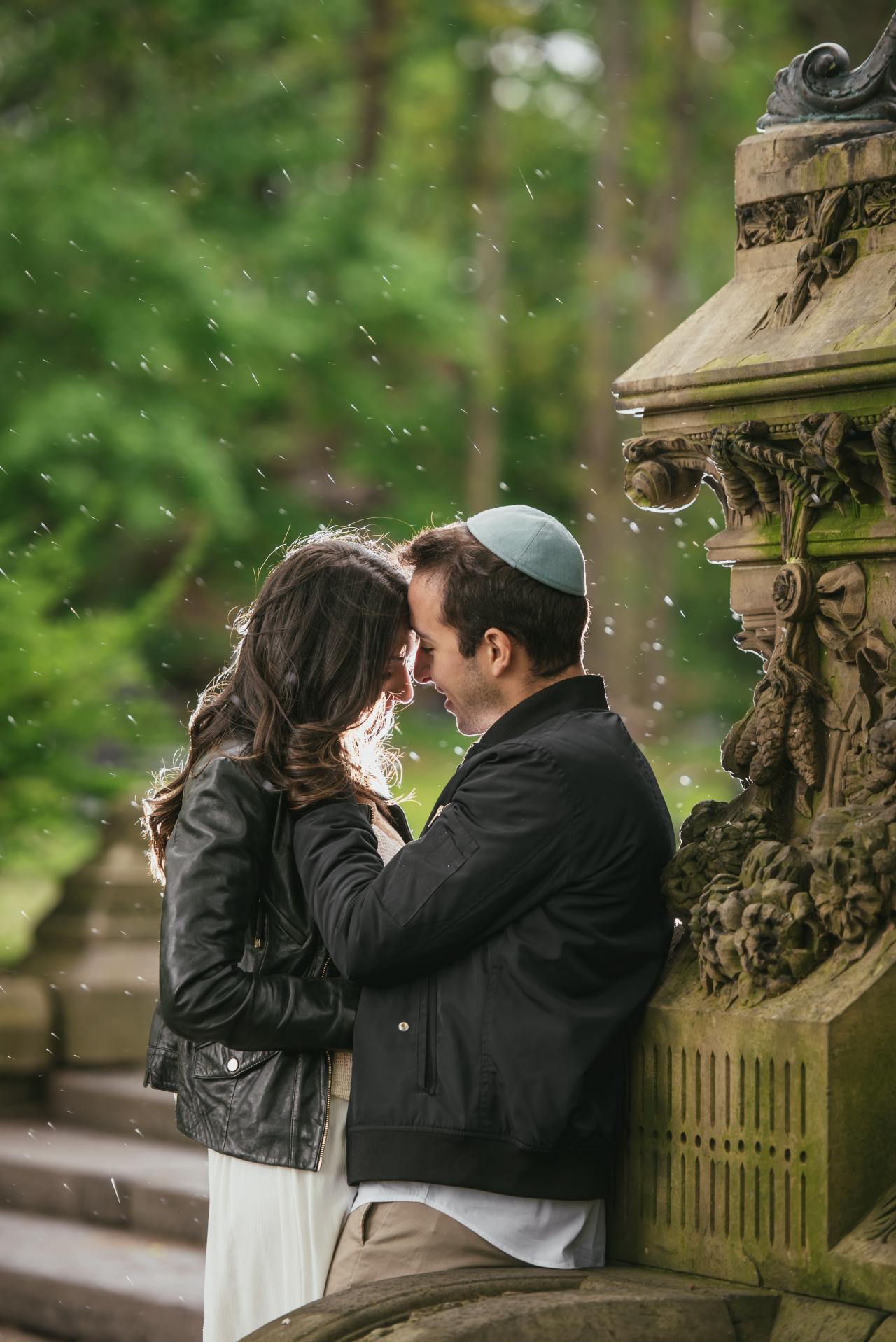 Couple sharing a kiss beside a stone balustrade