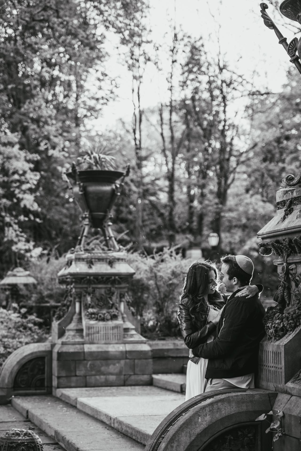 Black-and-white engagement portrait beside decorative park steps
