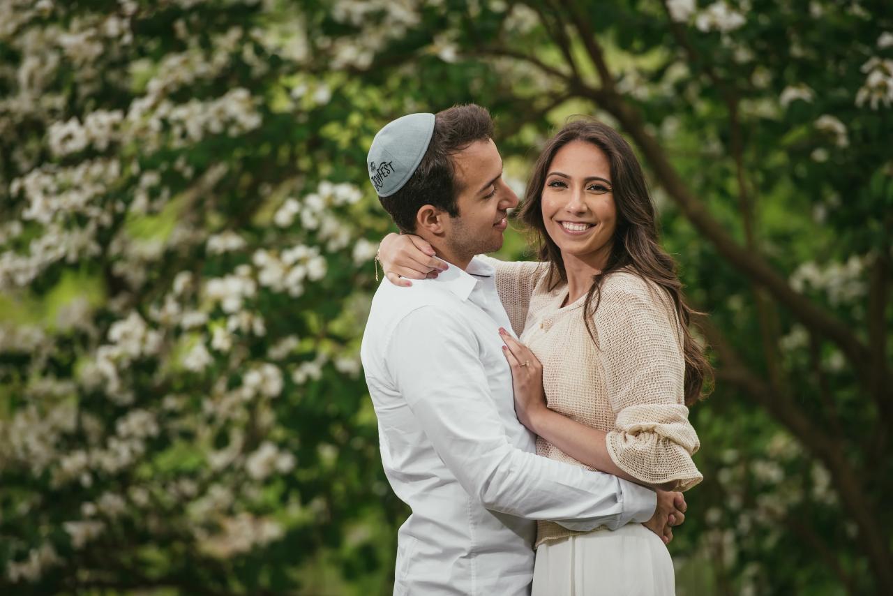 Couple smiling together in front of a flowering tree