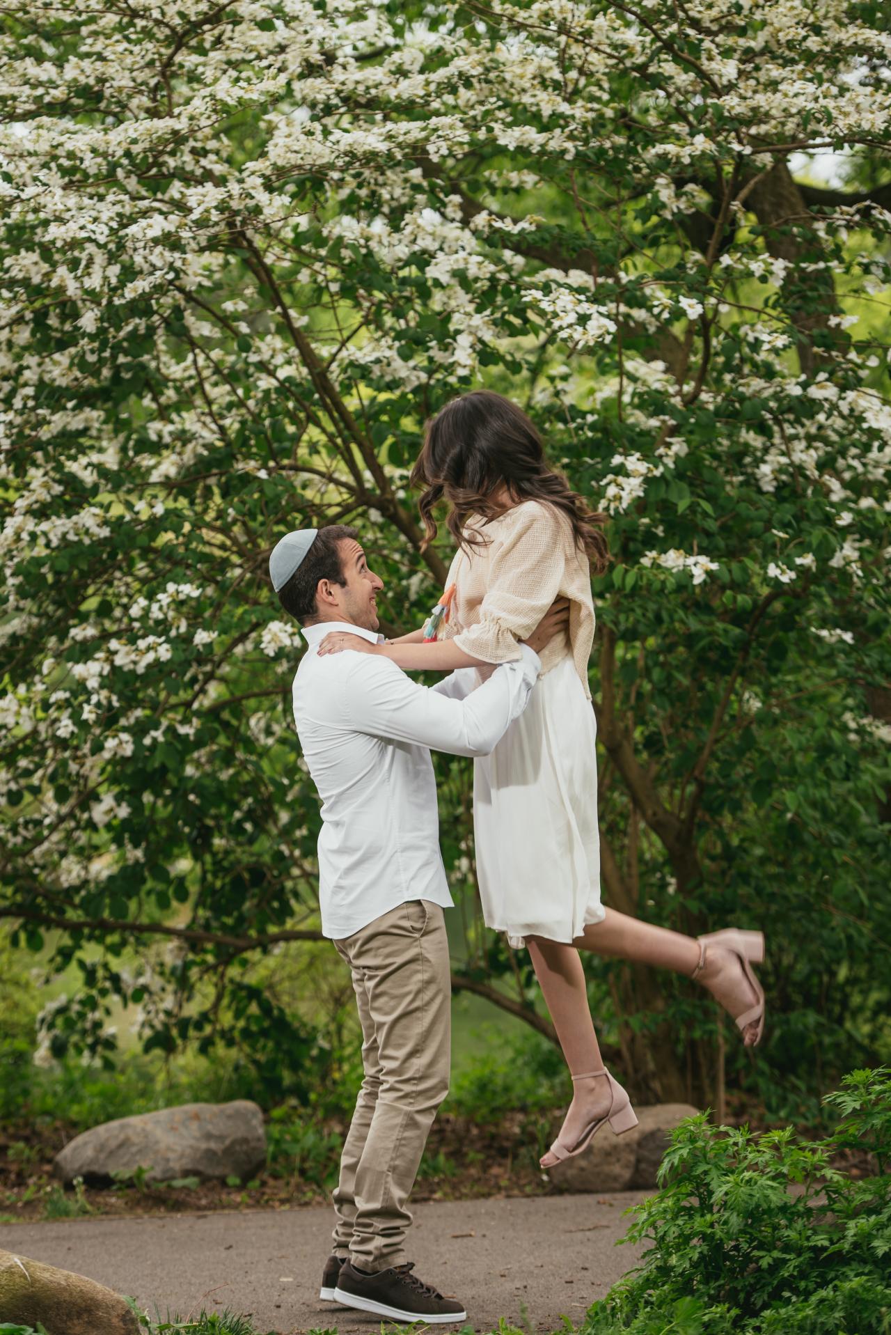 Playful couple portrait beneath a flowering tree