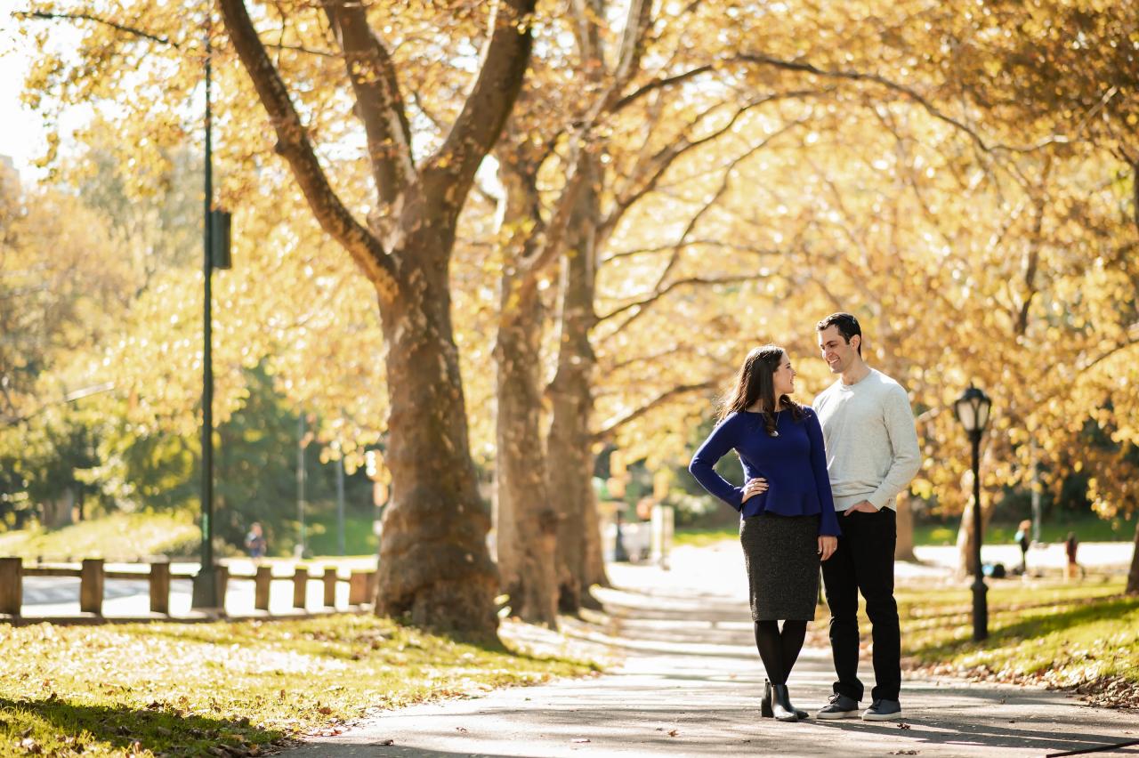 Wide couple portrait beneath a canopy of golden leaves