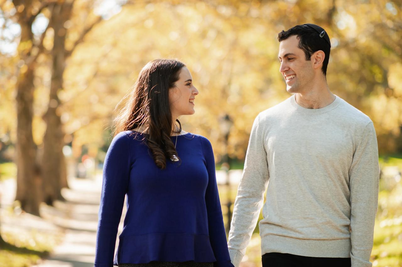 Close portrait of a couple smiling at each other while walking