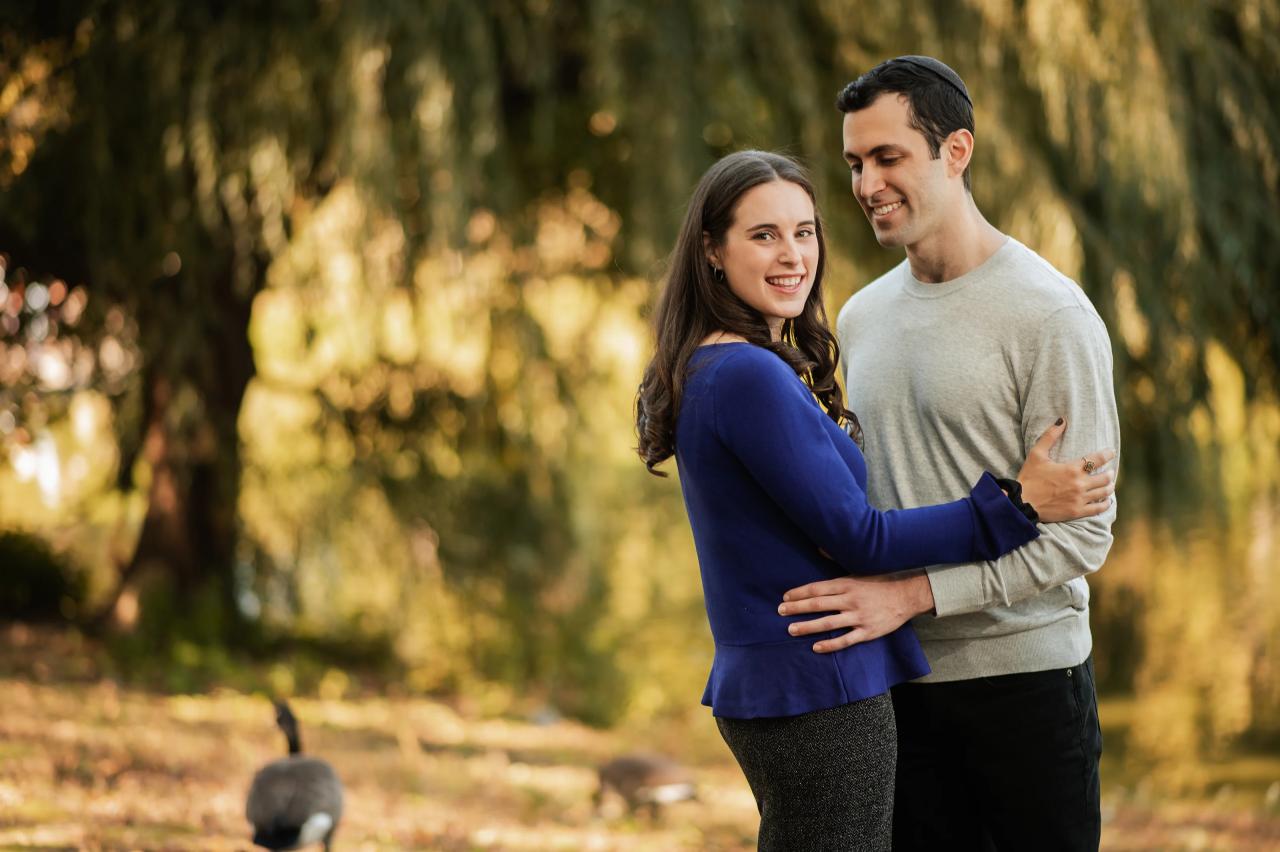 Couple embracing beneath willow branches