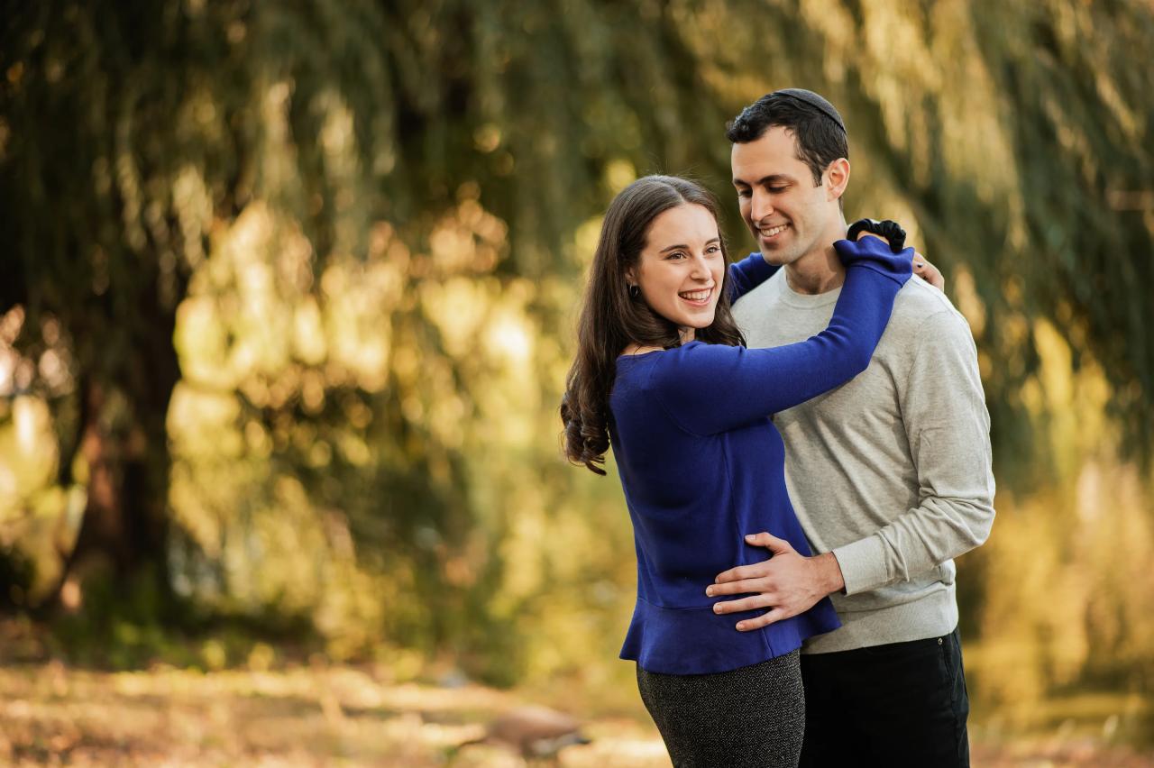 Close portrait of a couple sharing an embrace beside a willow tree