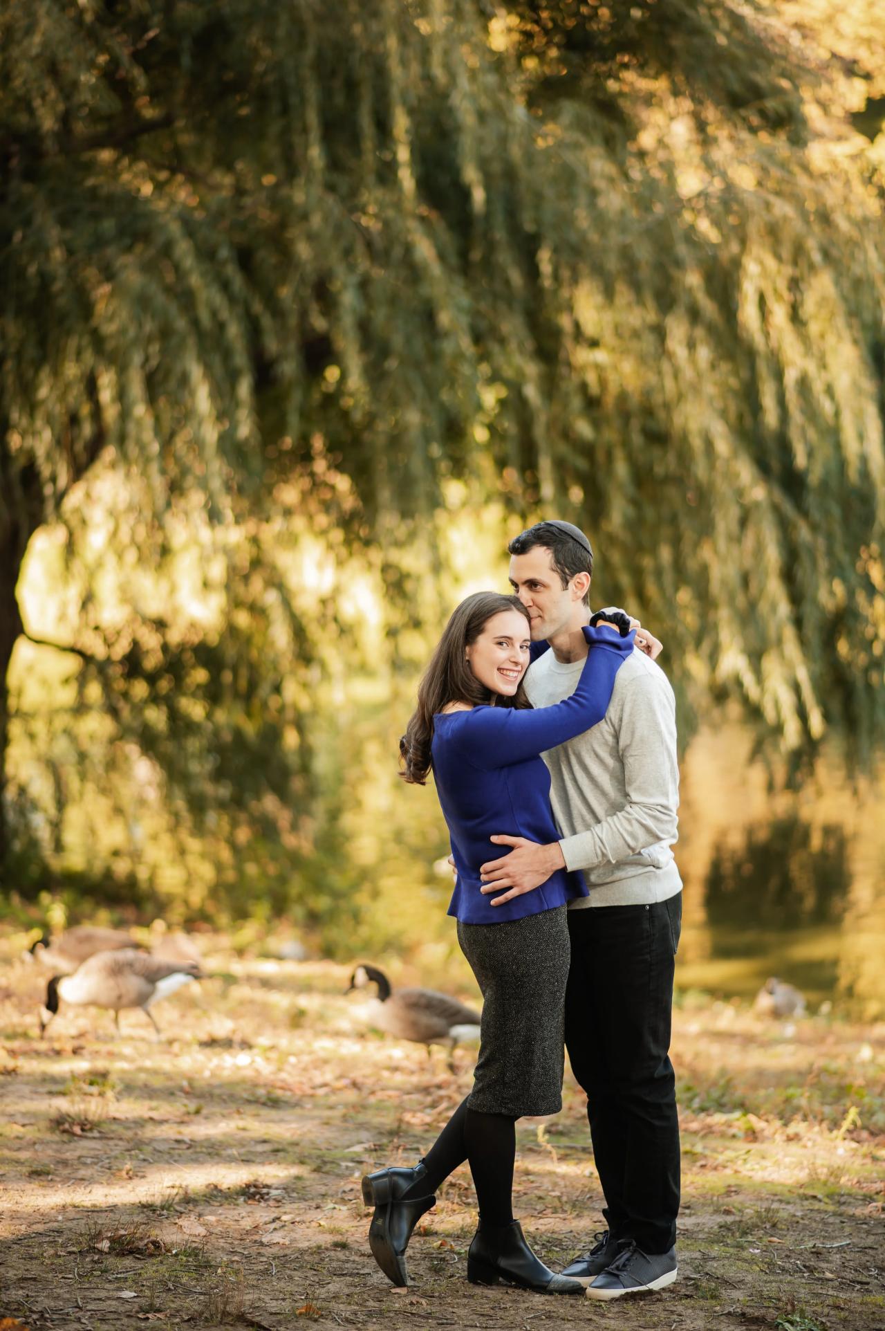 Full-length couple portrait beneath golden willow branches