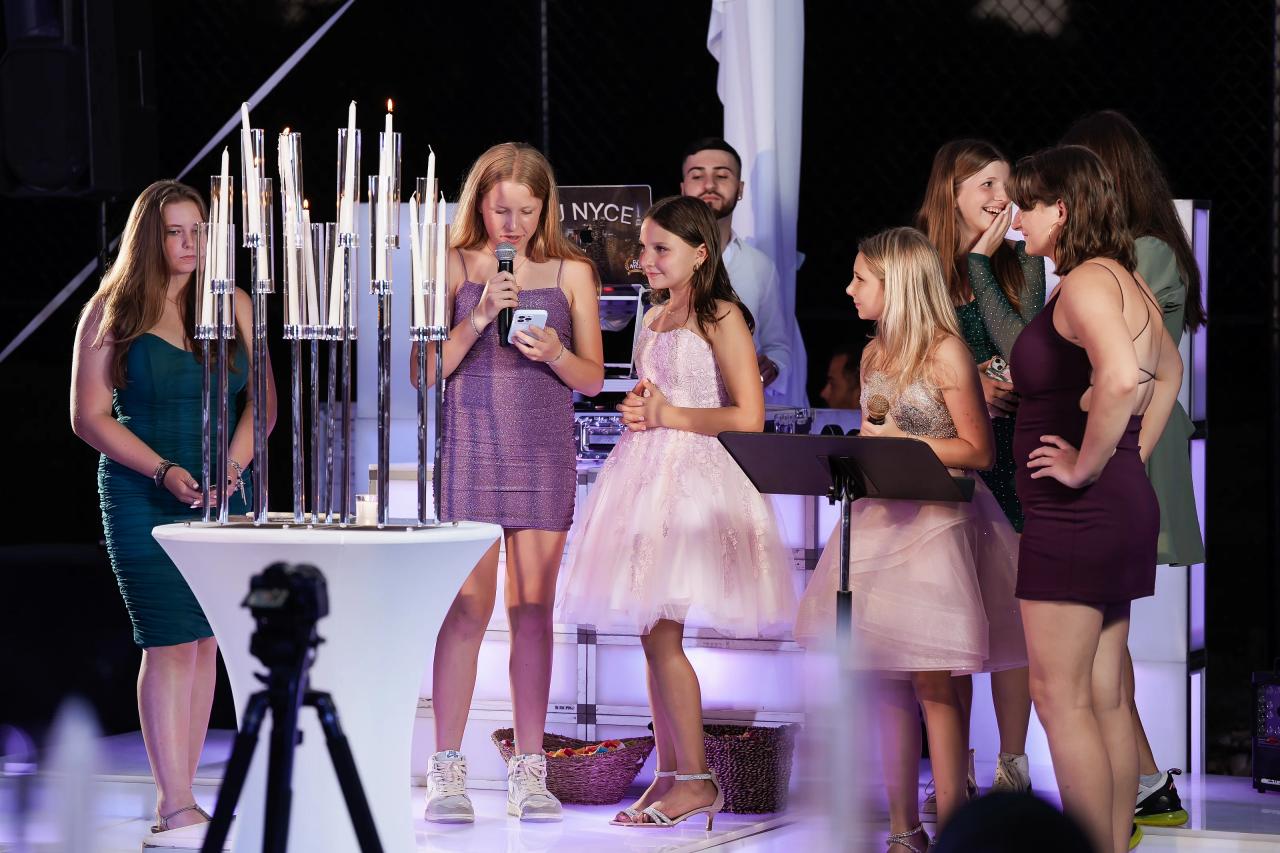 Twin sisters and friends gathered beside a candle display during the reception