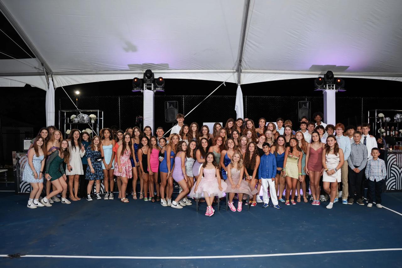 Large group portrait of the twin bat mitzvah guests beneath the reception tent