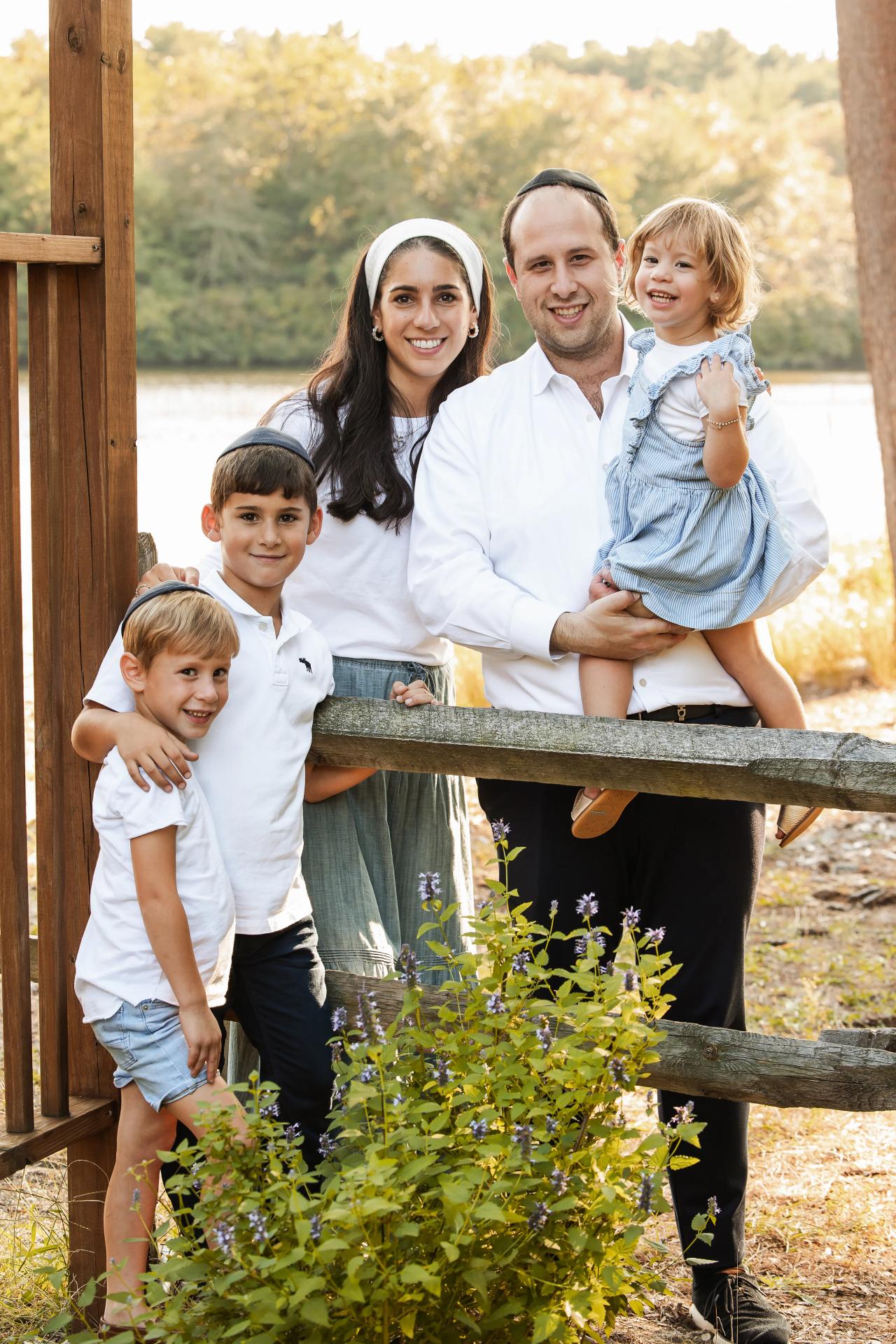 Family portrait beside the water with golden autumn leaves in the background