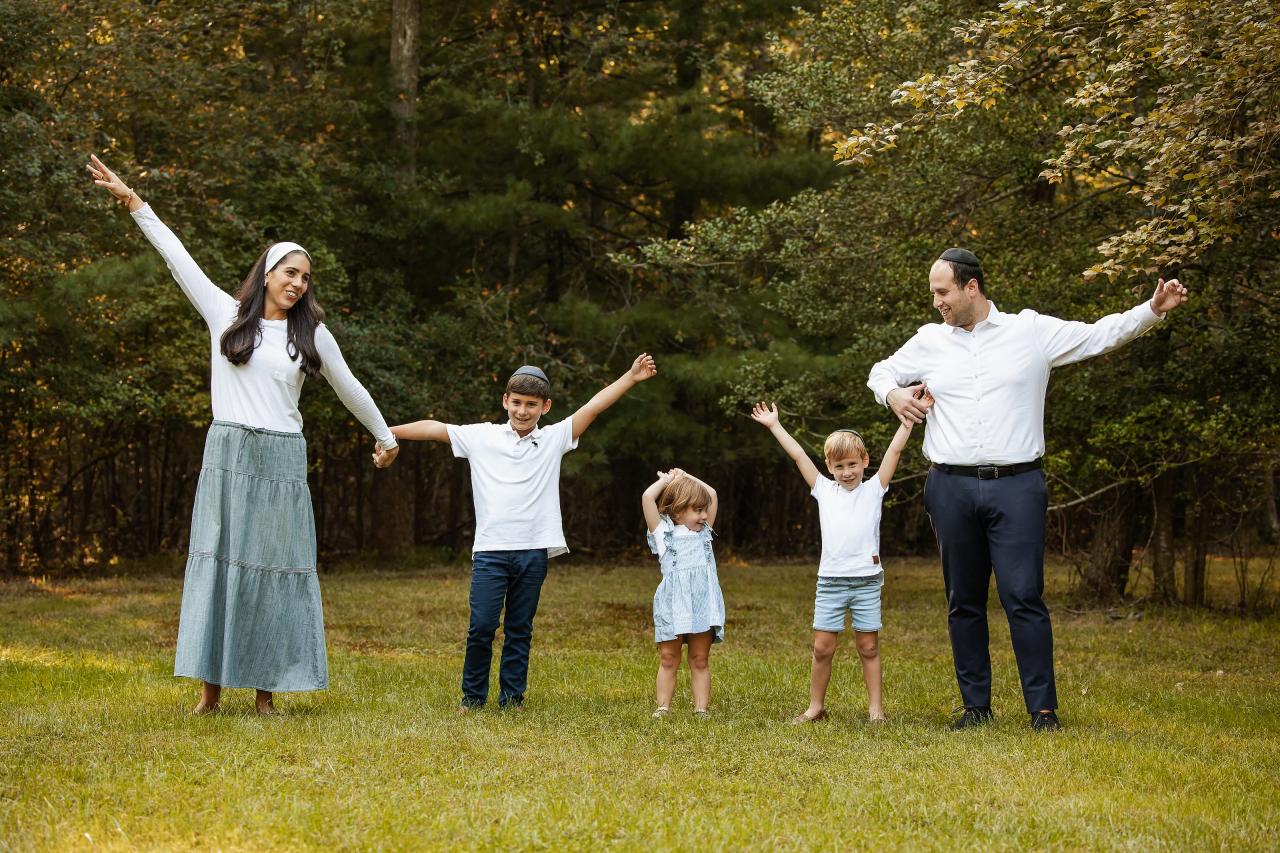 Parents and children raising their joined hands on the lawn
