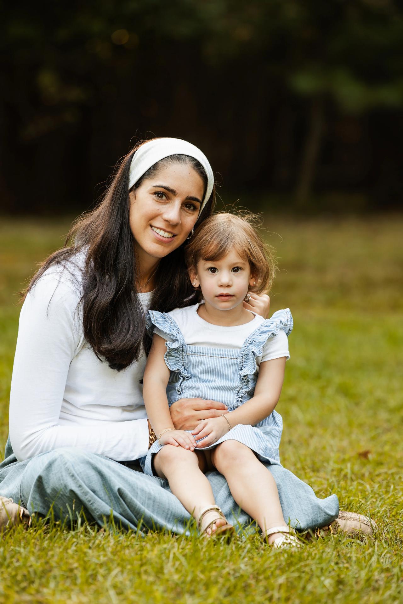 Mother and daughter smiling together on the lawn