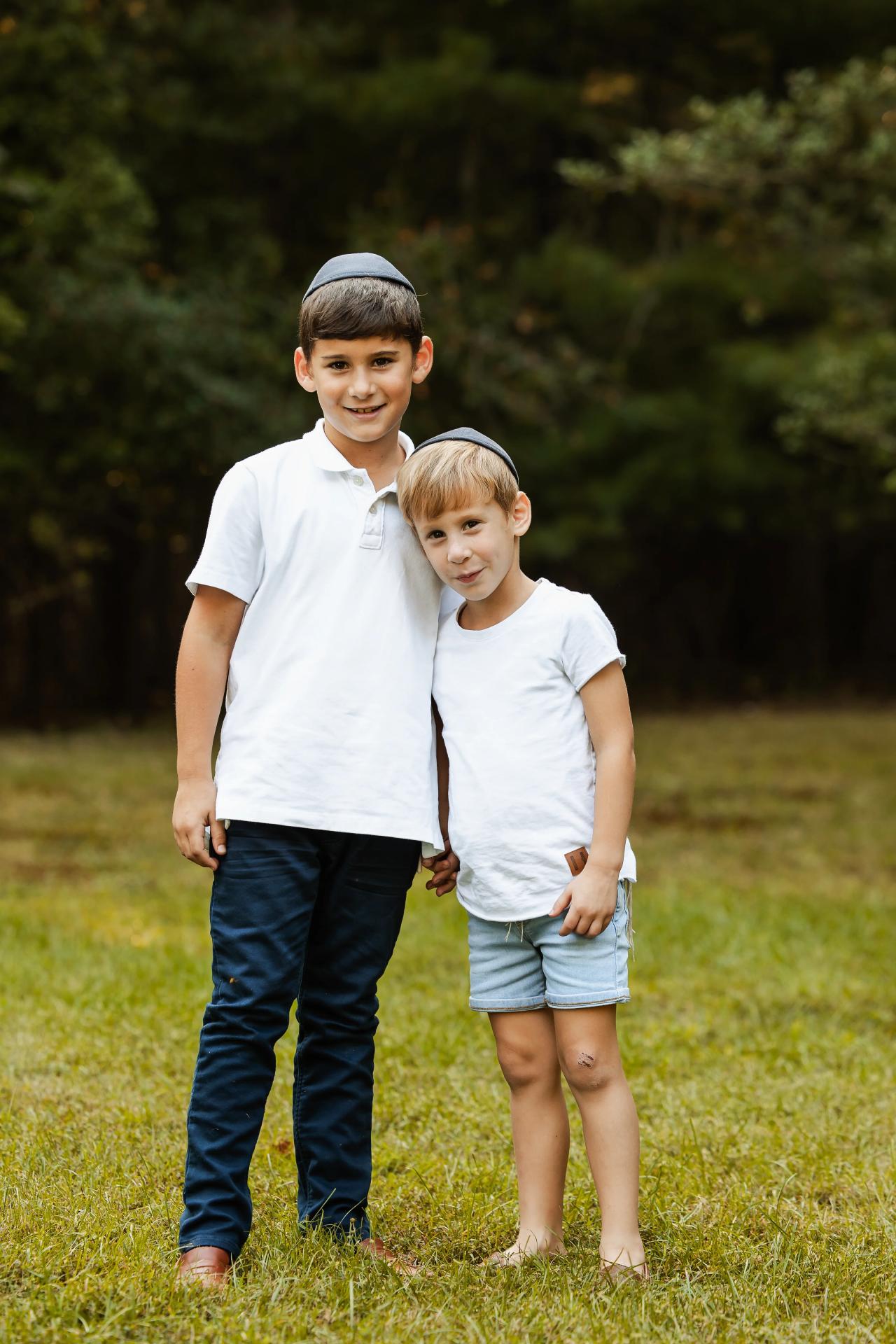 Two brothers standing together with an arm around one another
