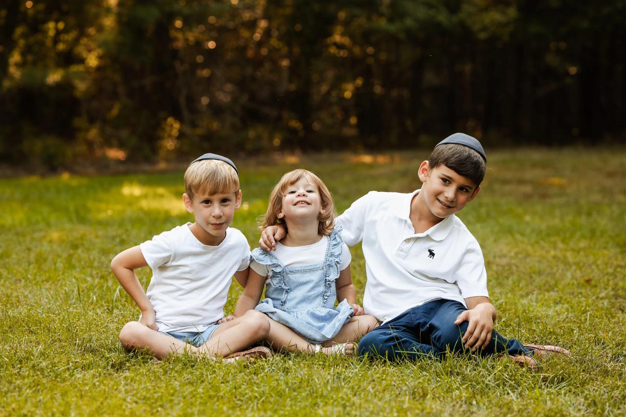 Little girl laughing while seated between her brothers