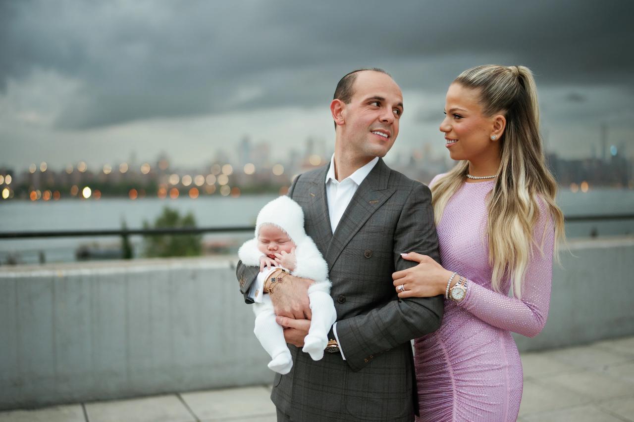 Father holding the baby while smiling at mother on the terrace