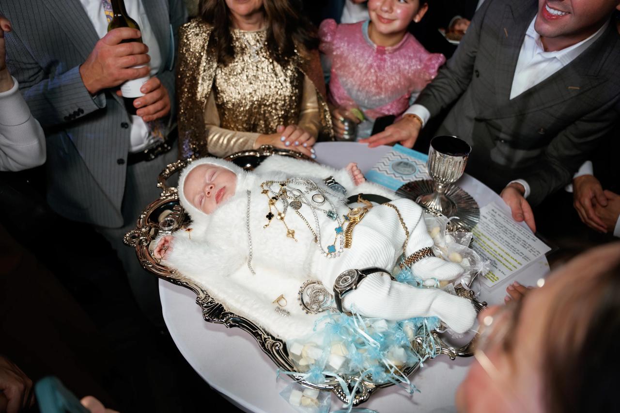 Baby on the decorated ceremony cushion surrounded by family members