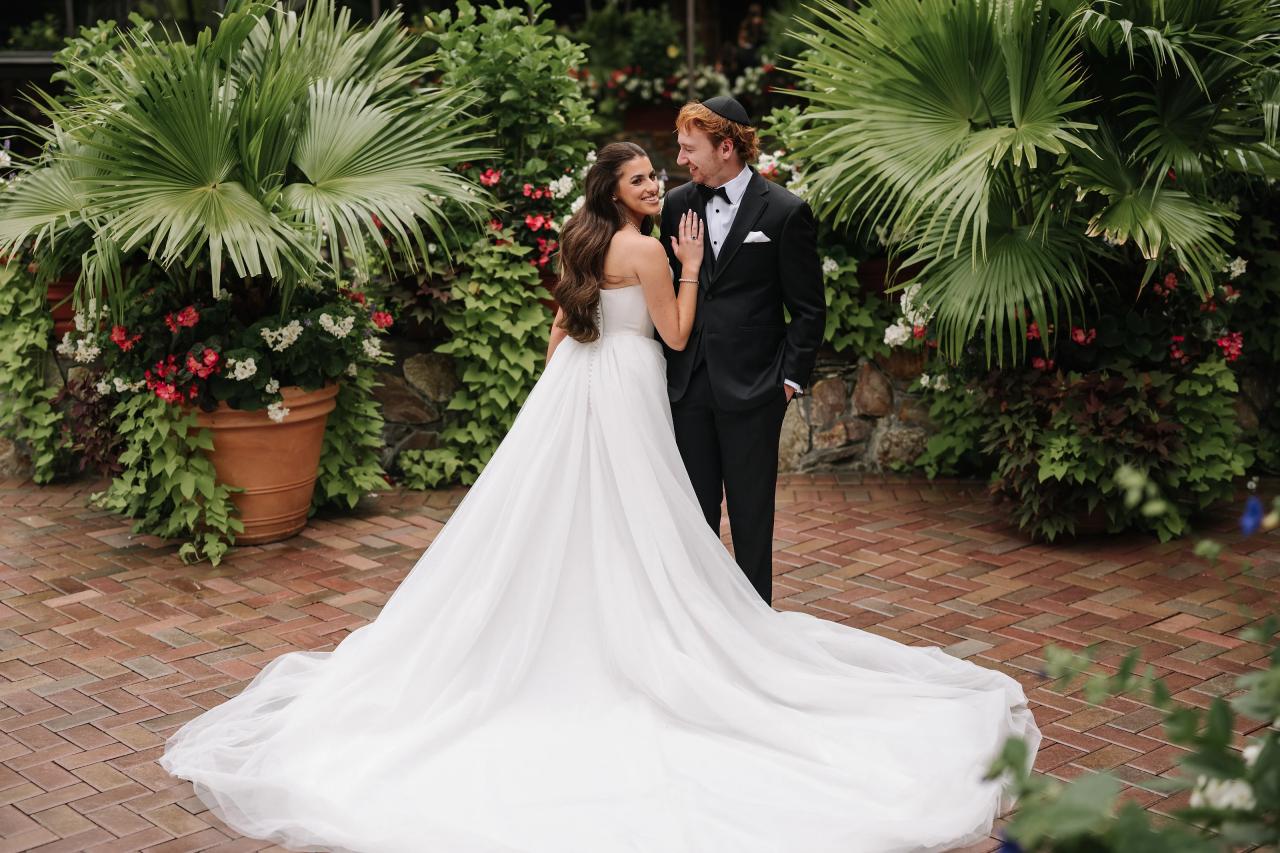 Bride and groom embracing among tropical palms at Crest Hollow