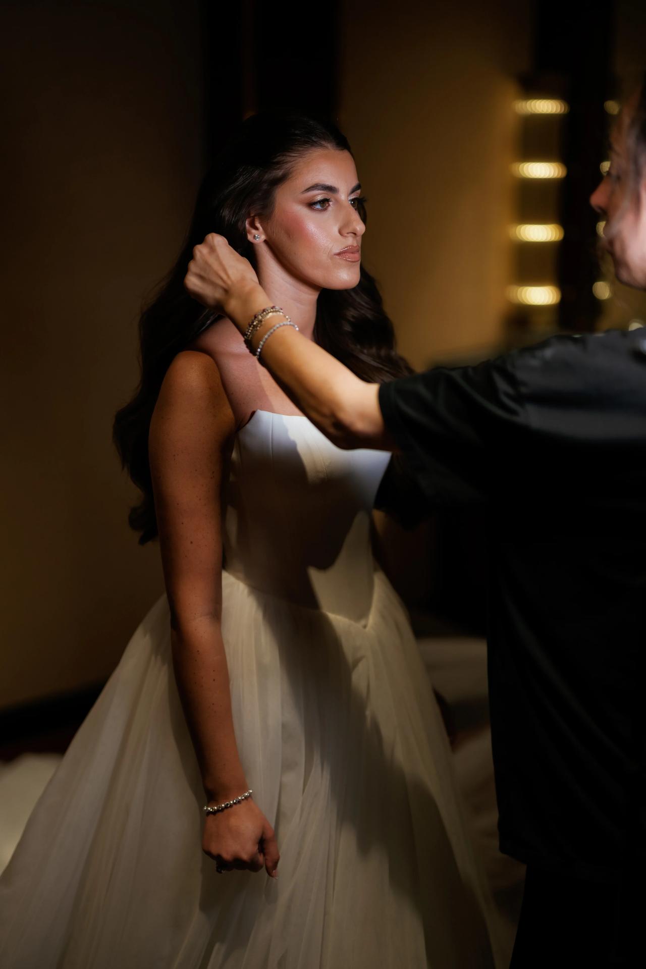 Bride getting ready in soft window light. Crest Hollow wedding in Woodbury, Long Island.