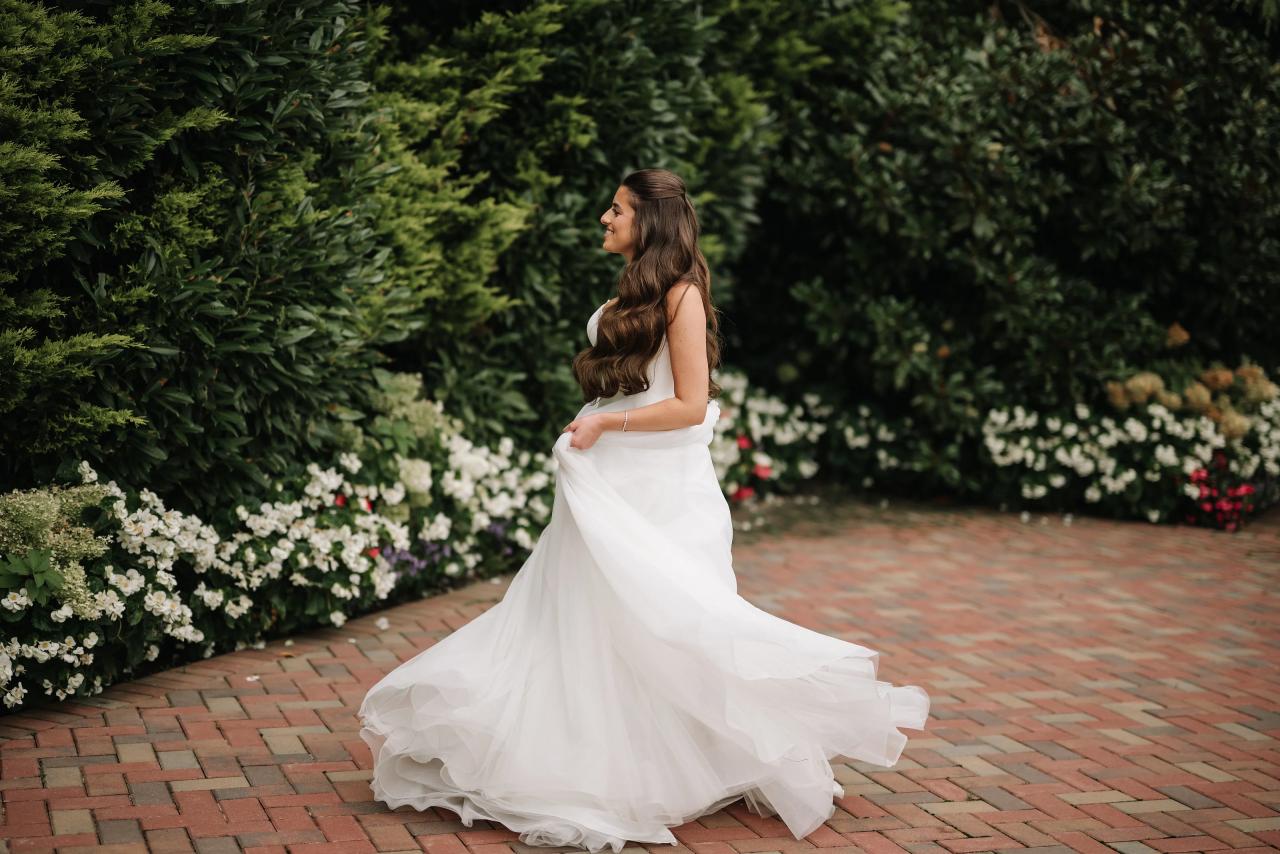 Bride twirling her wedding dress on a garden path. Crest Hollow wedding in Woodbury, Long Island.