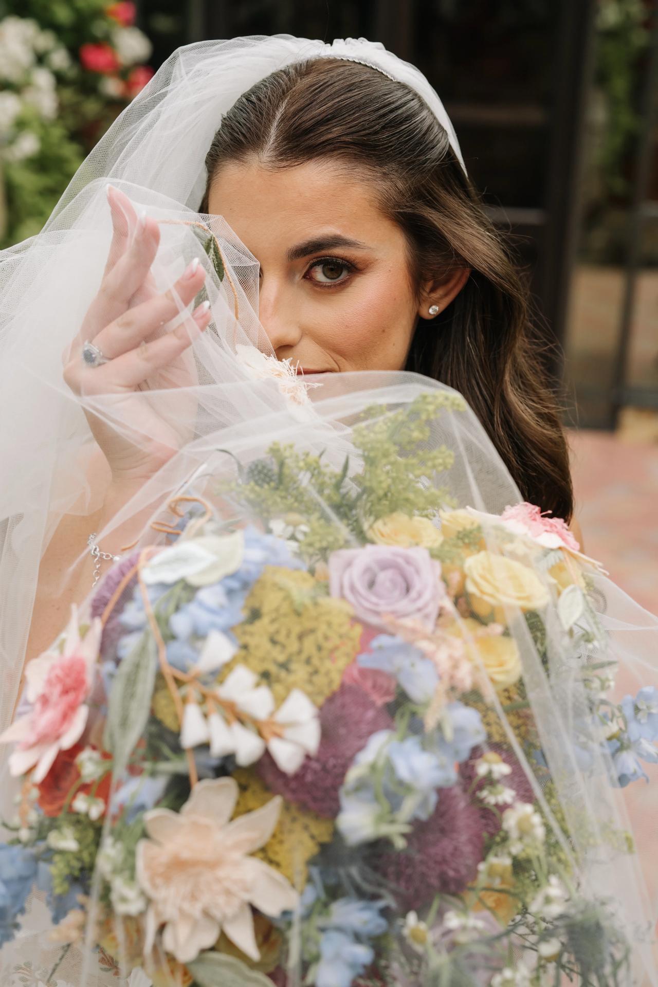 Close bridal portrait framed by a veil and colorful flowers. Crest Hollow wedding in Woodbury, Long Island.