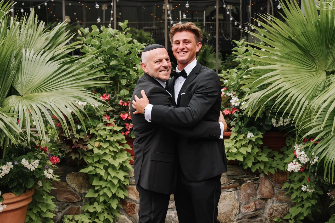 Groom sharing a joyful hug with a family member. Crest Hollow wedding in Woodbury, Long Island.