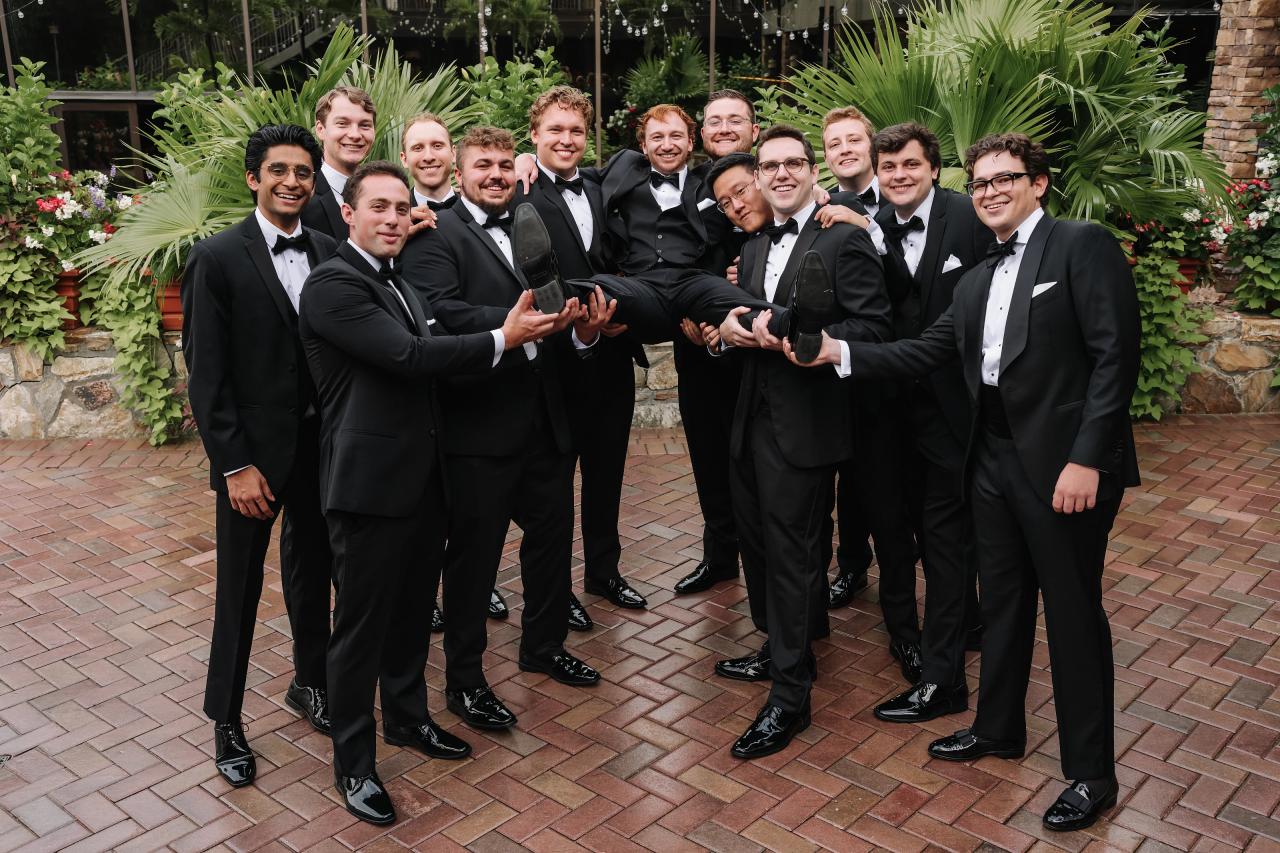 Groom celebrating with his wedding party outdoors. Crest Hollow wedding in Woodbury, Long Island.