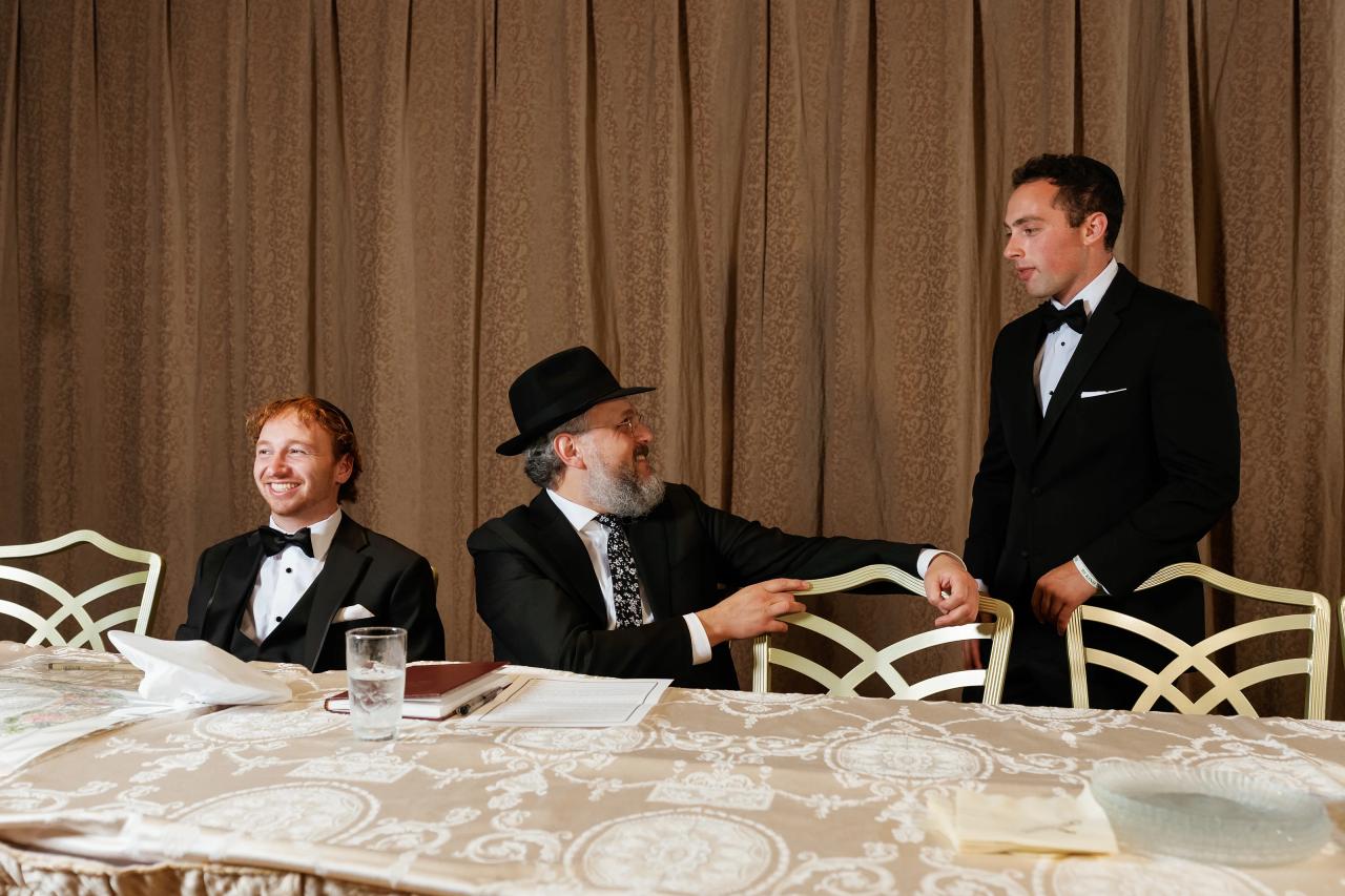 Groom seated with family during the wedding tish. Crest Hollow wedding in Woodbury, Long Island.