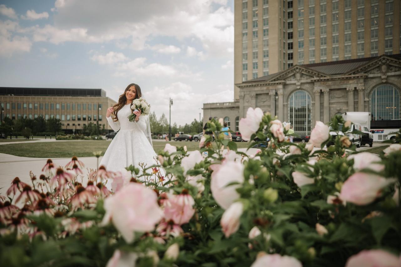 Bride framed by pink and white flowering shrubs. Jewish wedding in Detroit.