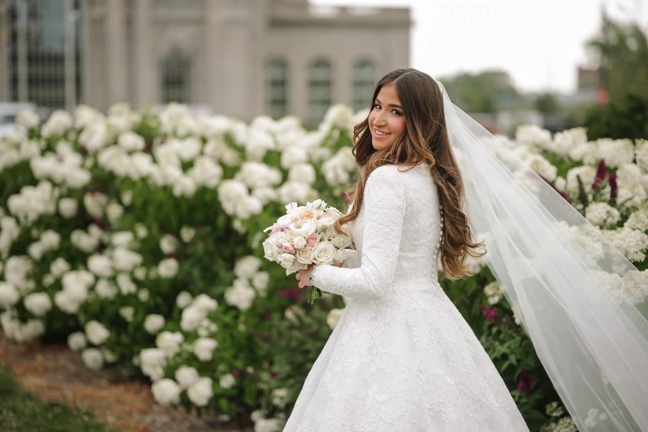 Bride looking back with her veil flowing in the garden. Jewish wedding in Detroit.