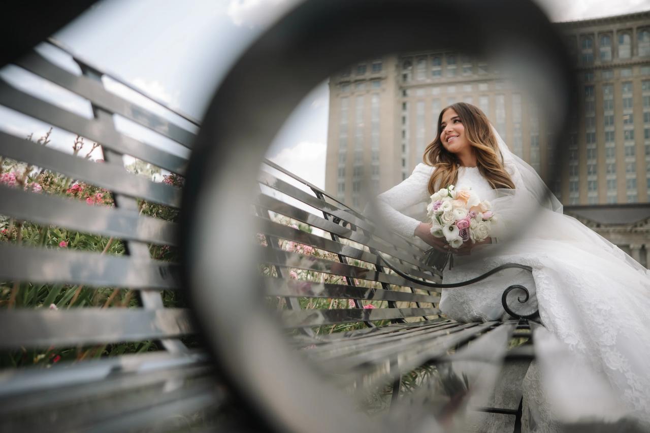 Bridal portrait framed through the curves of a garden bench. Jewish wedding in Detroit.