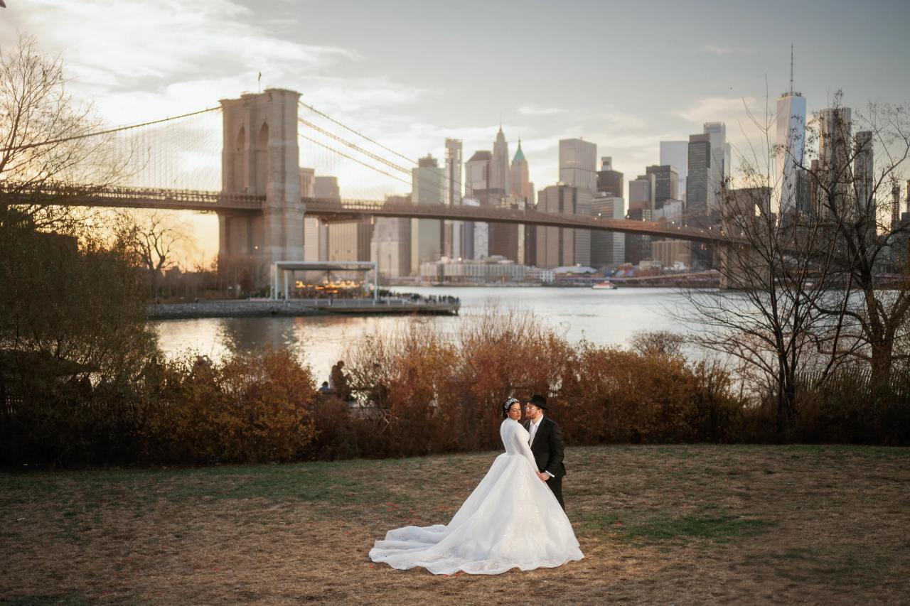 Wide wedding portrait on the lawn with the Brooklyn Bridge beyond