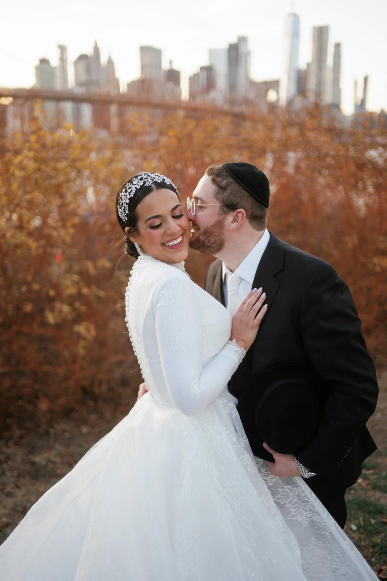 Groom kissing the bride’s cheek in soft evening light. Wedding portraits in Brooklyn, NYC.